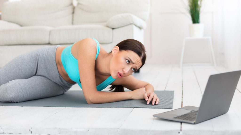 a woman working out while looking at her computer screen