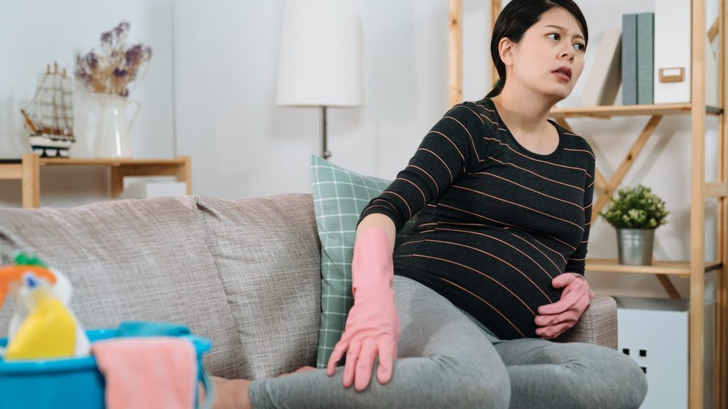 A woman in the middle of cleaning, noticing swelling in her calves