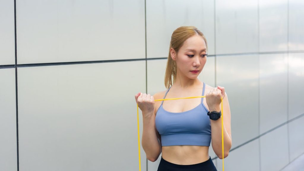 チューブでトレーニングをしている女性