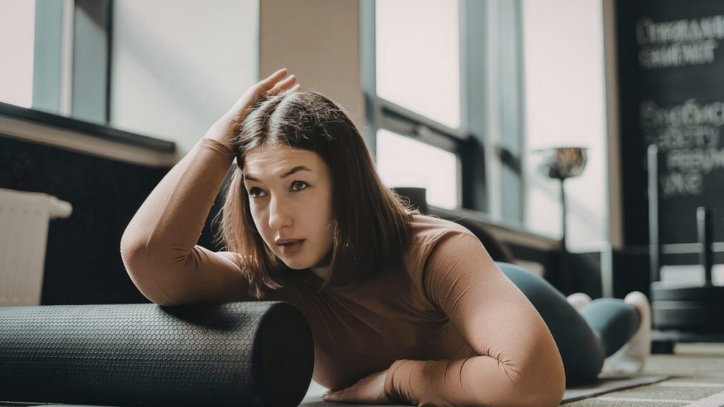 フォームローラーで体をほぐしている女性